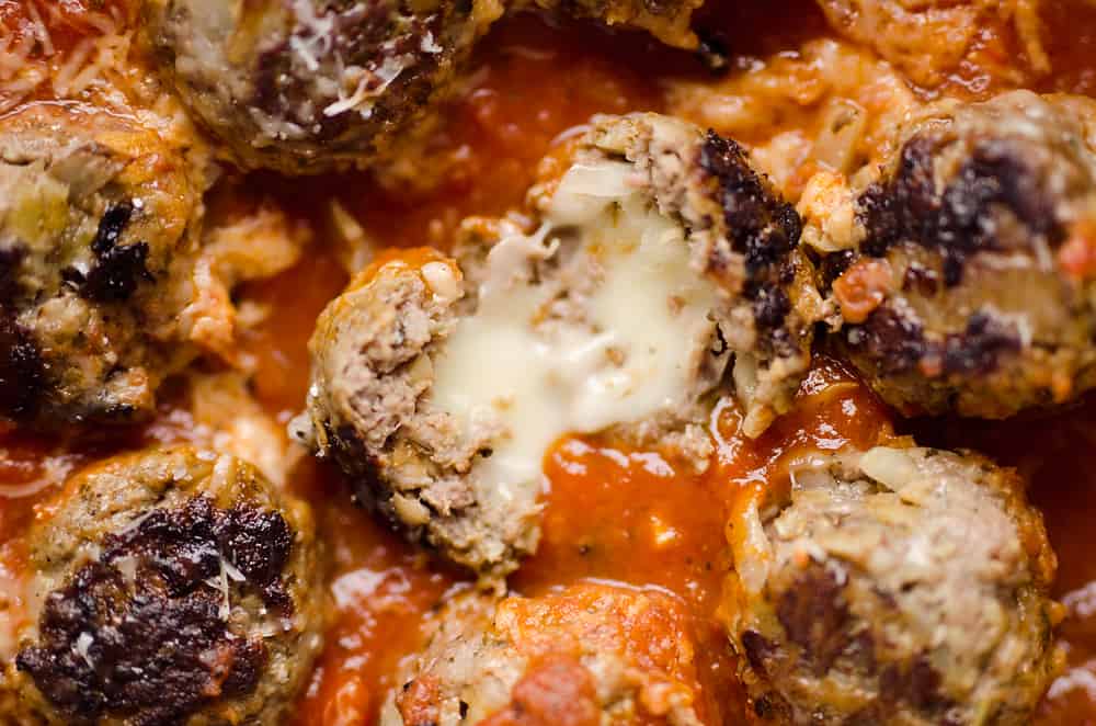Meatballs stuffed with provolone in pesto sauce.