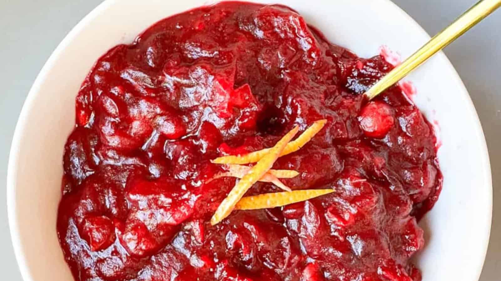 Tangy Asian cranberry sauce infused with orange and ginger flavors in a bowl with a golden spoon.