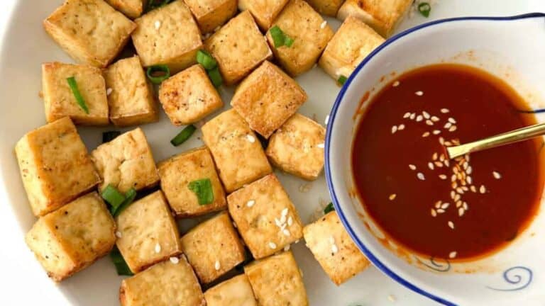 Crispy and golden vegan-friendly air fryer tofu nuggets on a white plate.