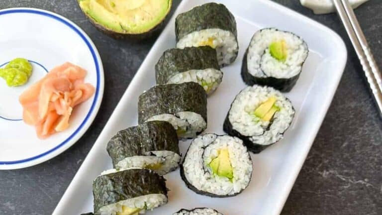Fresh and vegan-friendly avocado maki sushi rolls on a plate.