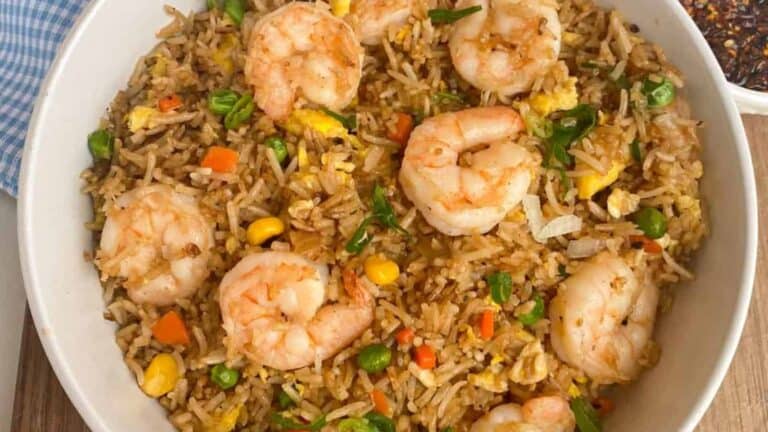 Flavorful shrimp fried rice with veggies in a white bowl.