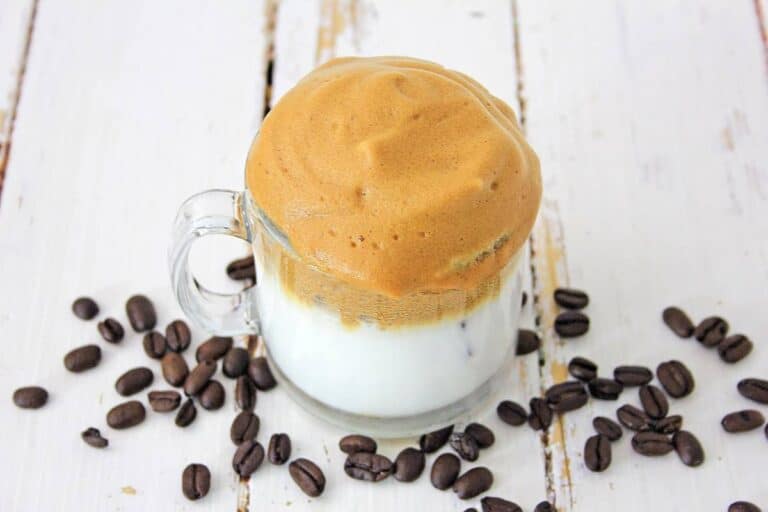 A coffee mug with coffee and chocolate.