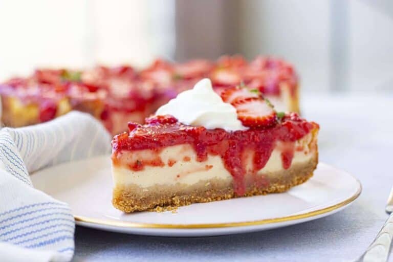 A slice of strawberry cheesecake on a plate.