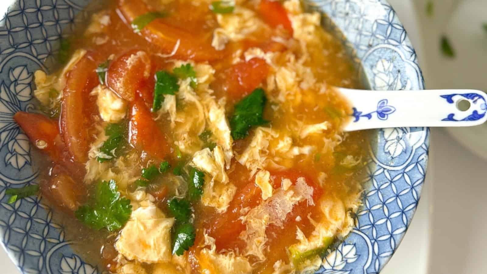 Tomato egg drop soup in a bowl with cilantro.