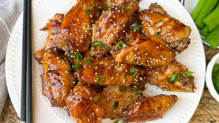 Baked tender, sticky, and savory Asian chicken wings on a plate.