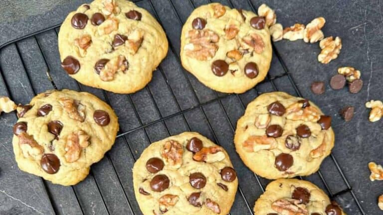 Soft and chewy chocolate chip cookies with crunchy walnuts on a cooling rack.