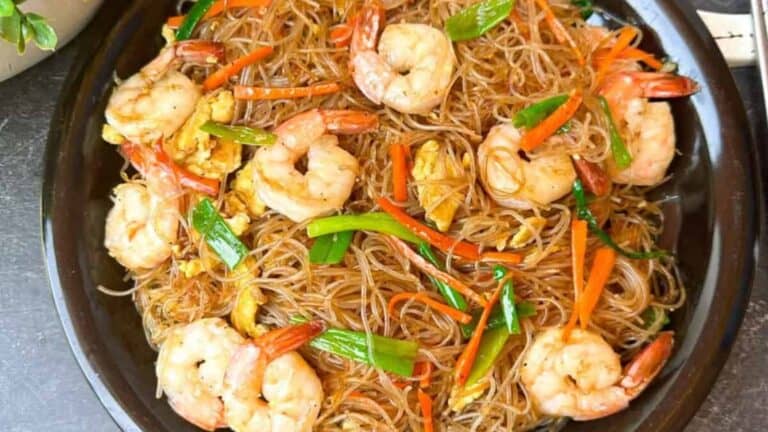 Savory shrimp stir-fried mei fun rice noodles on a plate.