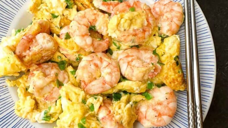 Soft and fluffy scrambled eggs stir fry tender shrimp on a plate.
