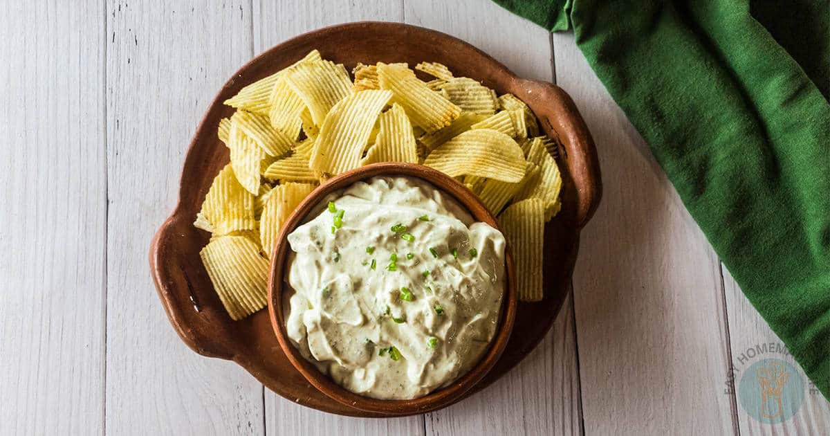 A picture of the best chip dip with potato chips on a tray.