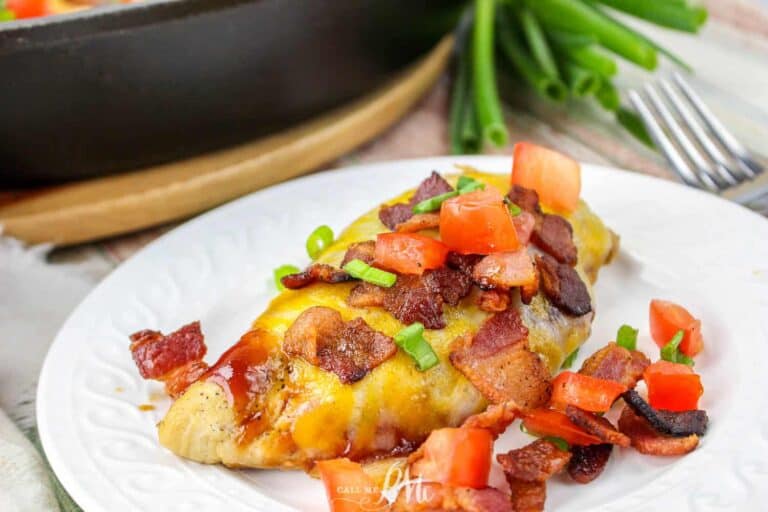 Cheese covered chicken in a skillet with a spatula.