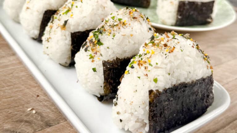 A plate of tuna onigiri, garnished with rice seasoning.