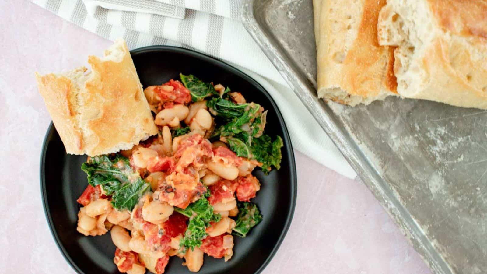 A hearty Tuscan white bean skillet with kale, featuring tender white beans, sautéed kale, and a flavorful garlic-infused broth, garnished with herbs for a delicious, healthy meal.