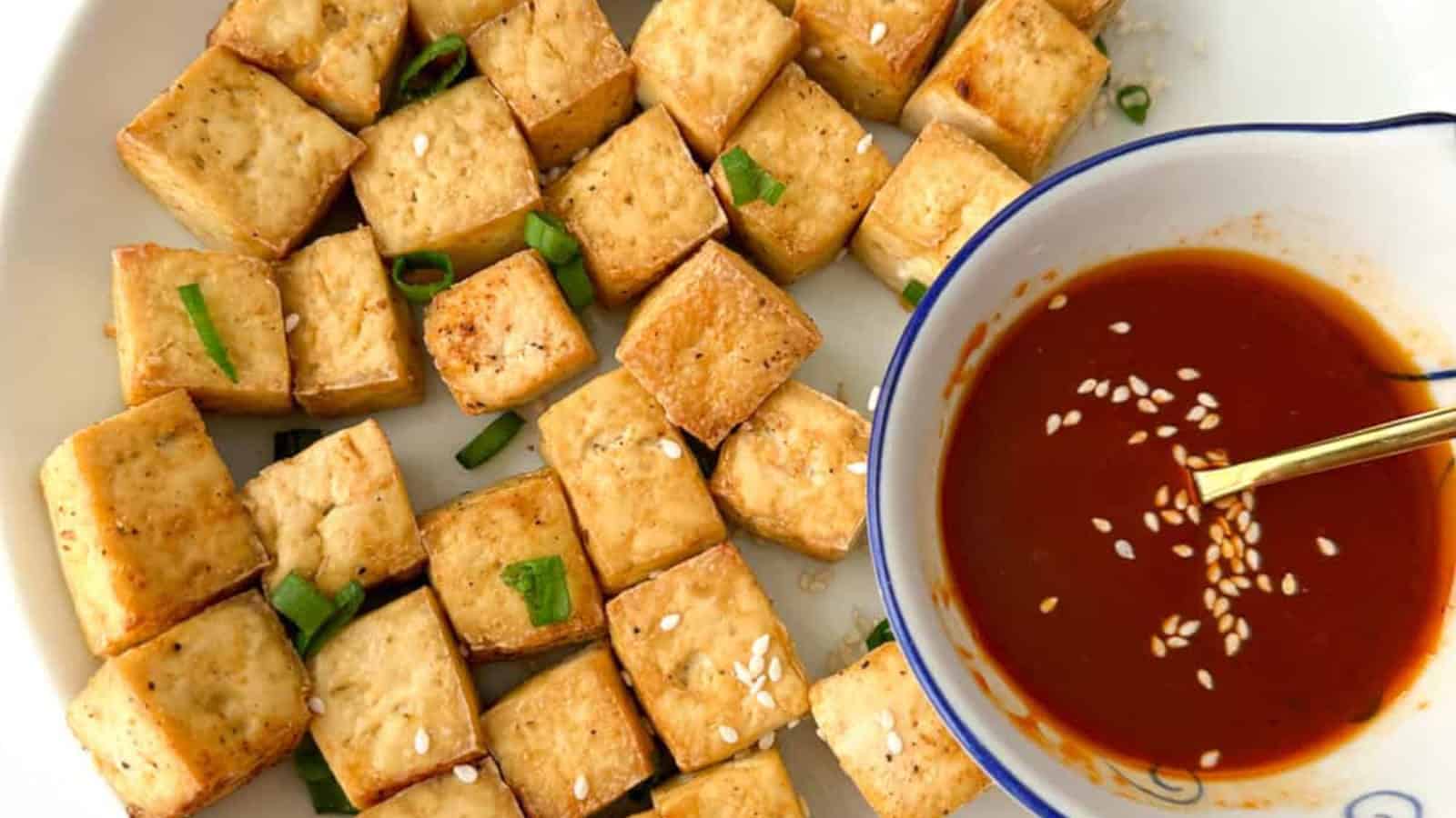 Crispy and golden vegan-friendly air fryer tofu nuggets on a white plate.