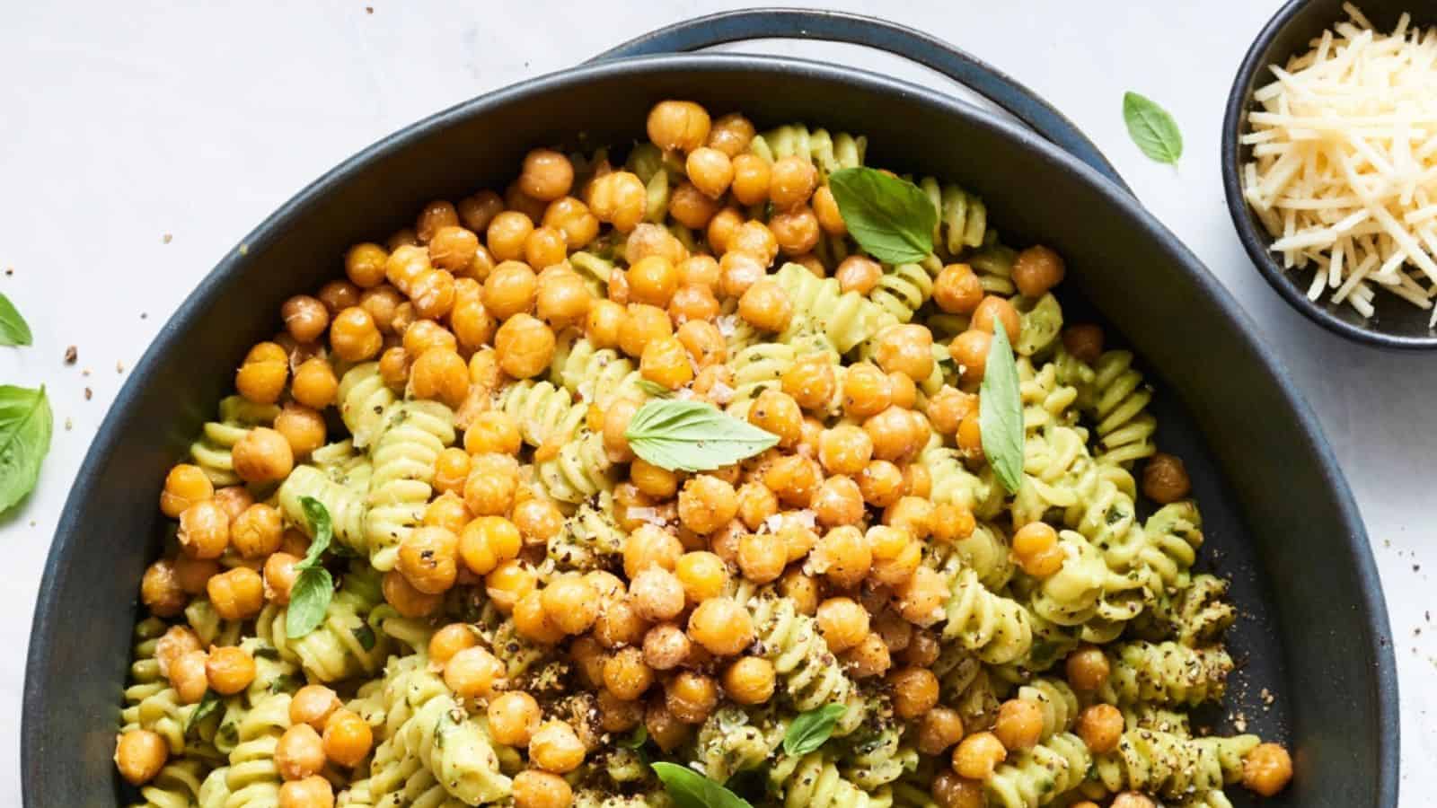 Avocado pesto pasta topped with crispy chickpeas and fresh basil.