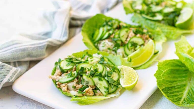 Thai chicken lettuce wraps with peanut sauce on a white plate.
