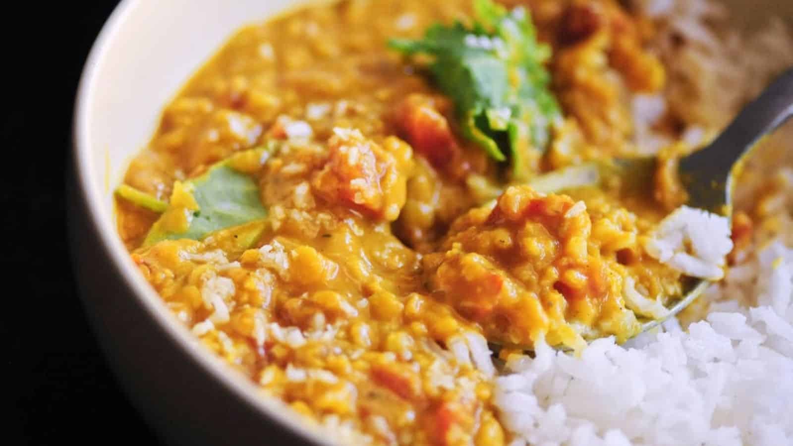 Spicy coconut red lentil dal served with white rice and cilantro.