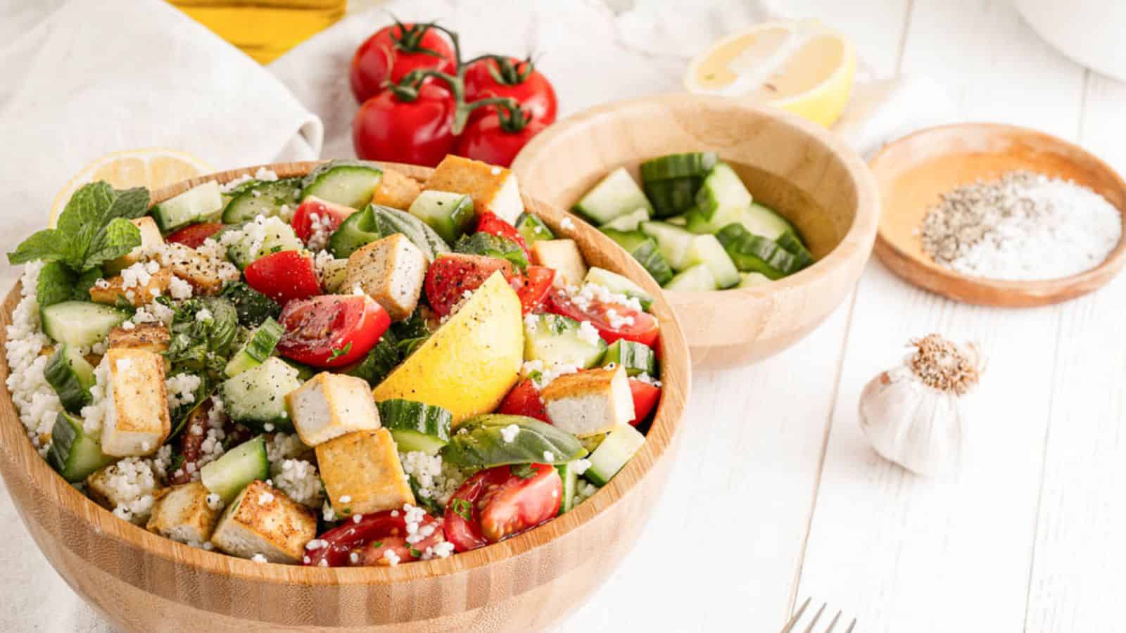 A vibrant couscous salad with fresh vegetables, herbs, and a light dressing, served in a bowl.