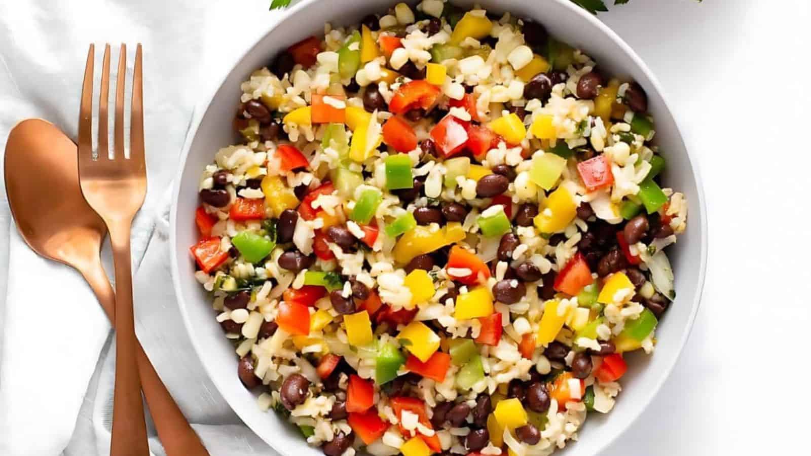 A bowl of festive Mexican rice salad with fresh veggies and cilantro.