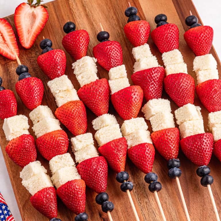 Berries and pound cake skewers on a cutting board.