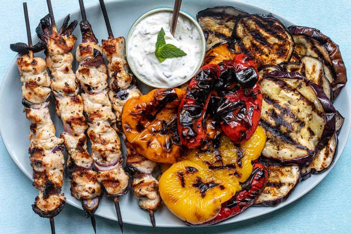 Greek chicken kabobs with grilled vegetables and tzatziki sauce.