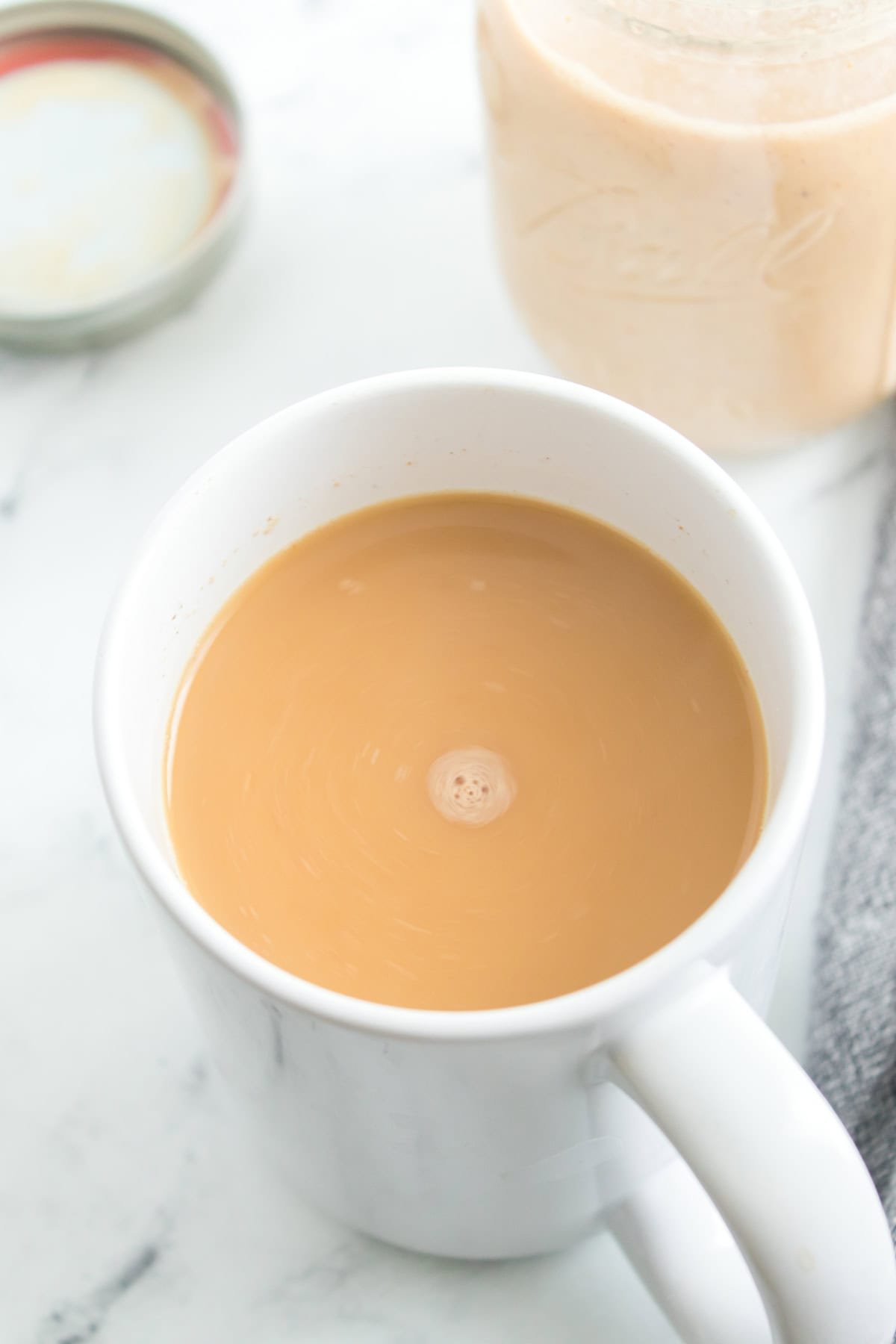 A white cup of coffee filled with homemade pumpkin-flavored creamer.