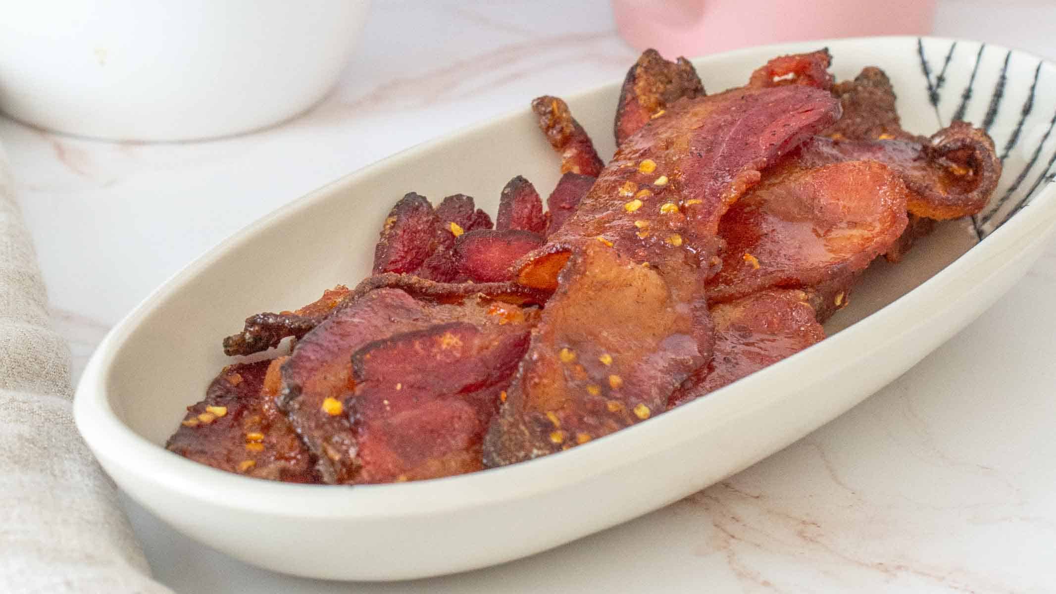Sweet and spicy glazed bacon strips, baked until crispy.