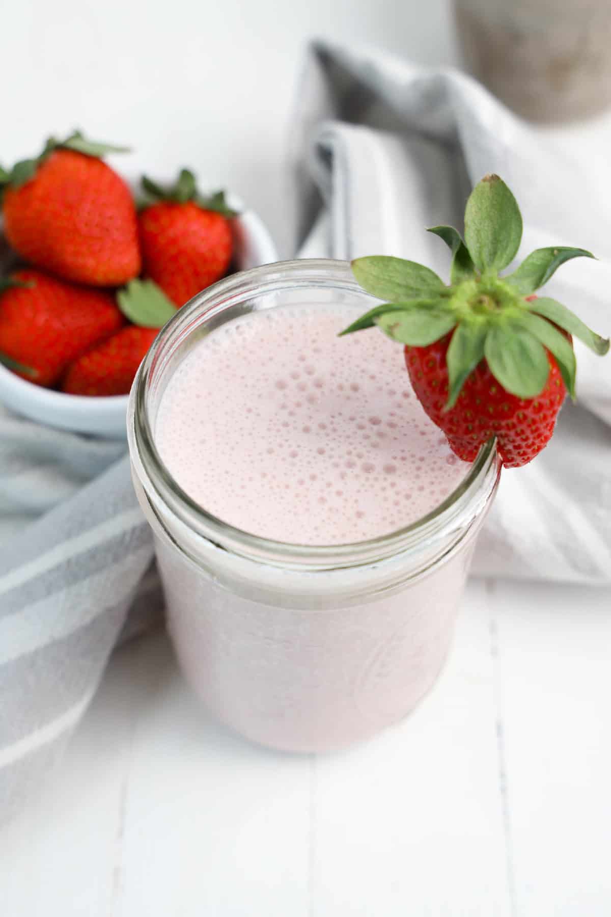 A colorful strawberry banana smoothie in a clear glass, showcasing a blend of strawberries and bananas.