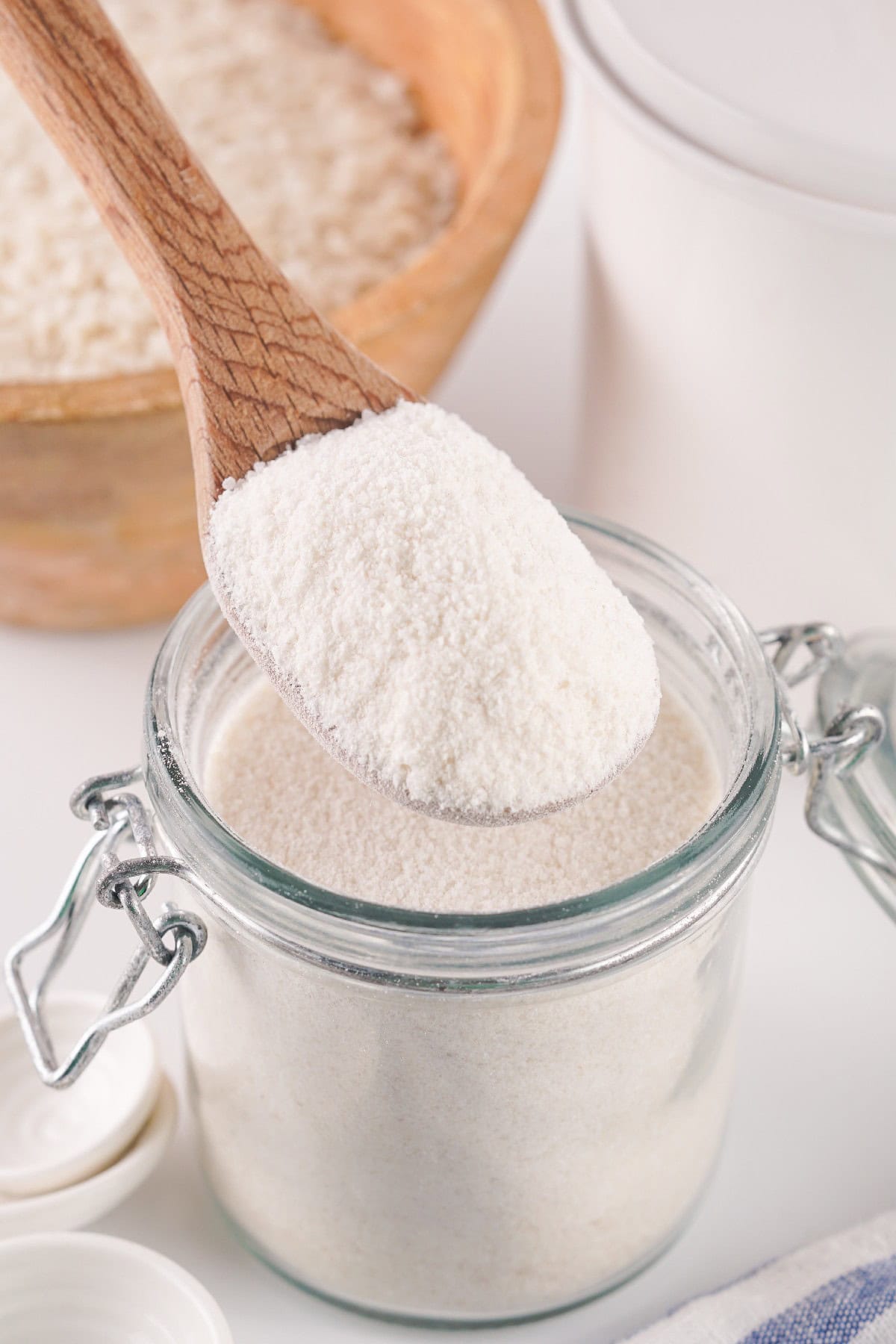 A jar with rice and wood spoon.
