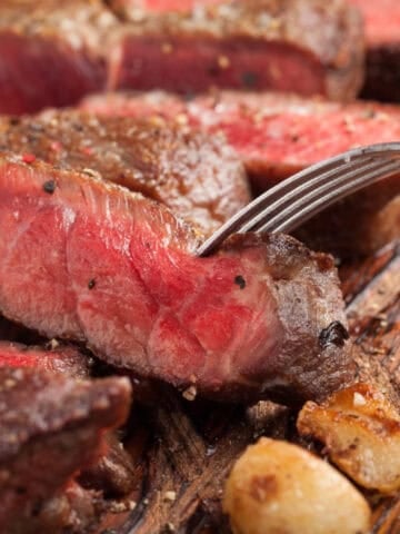 A juicy piece of steak with a fork resting on top.