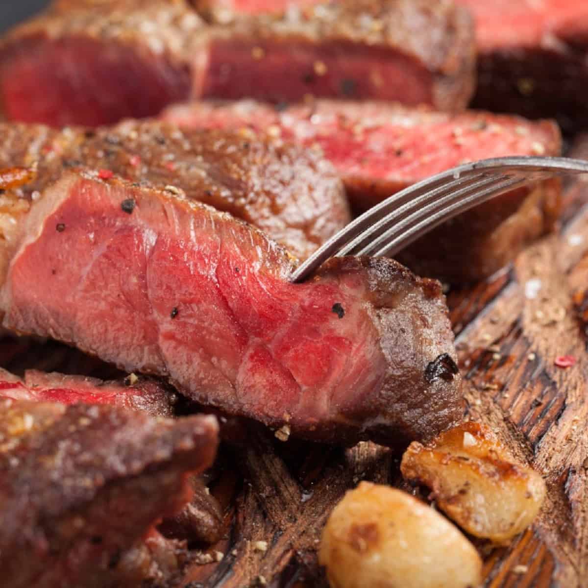 A juicy piece of steak with a fork resting on top.