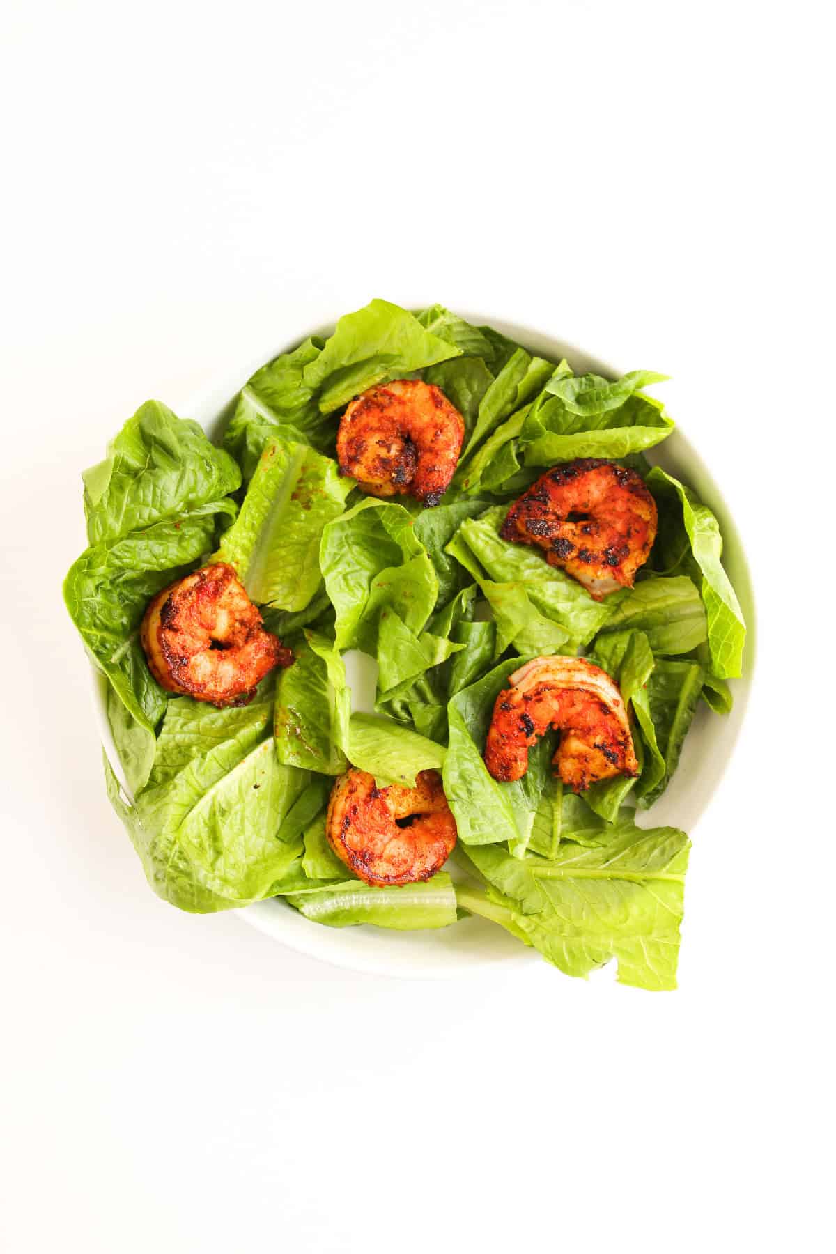 Blackened shrimp served on a bed of fresh romaine lettuce.