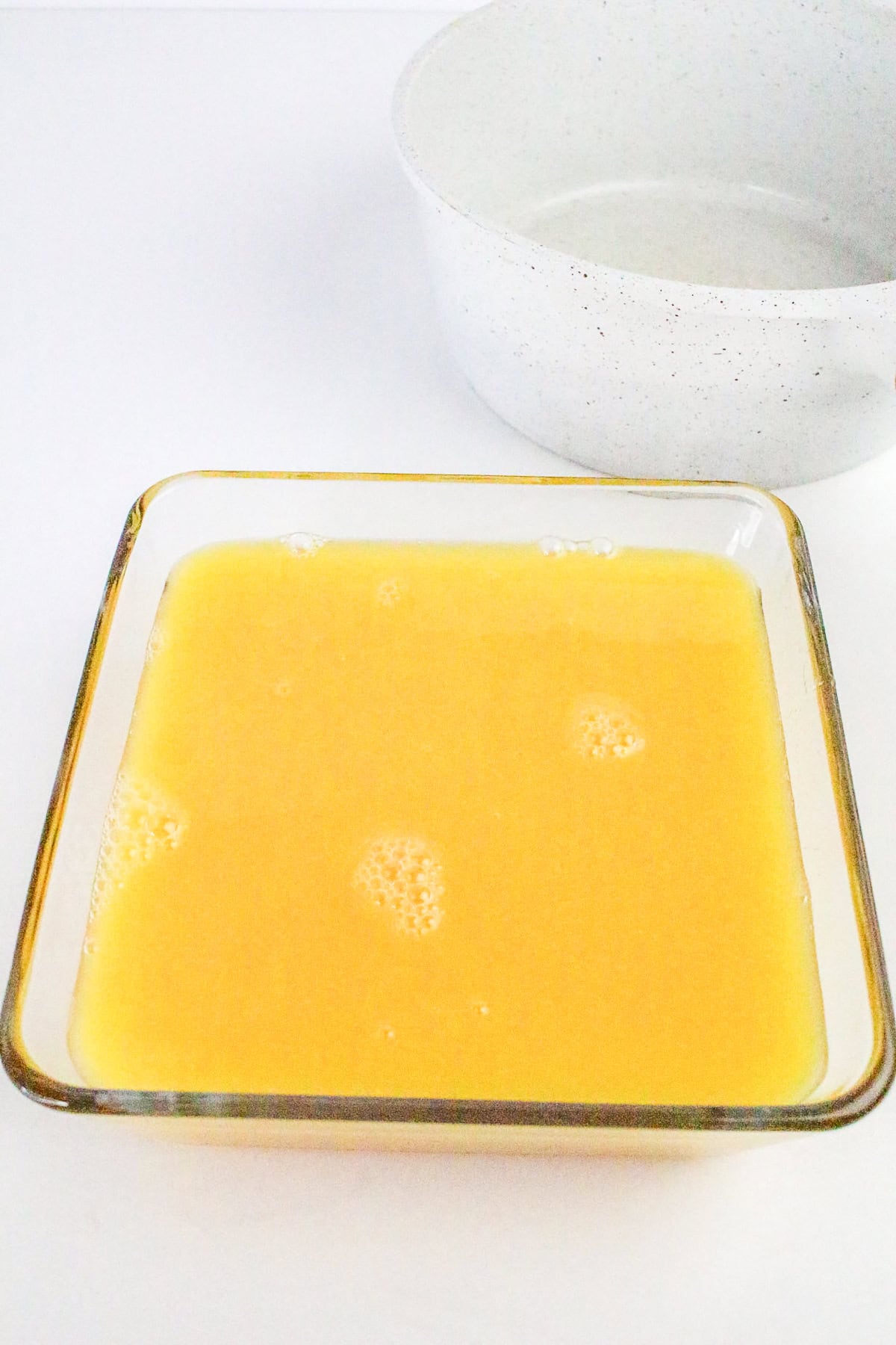 Orange sorbet mixture ready to freeze in glass dish.