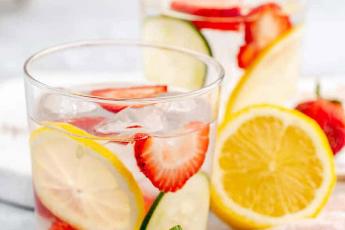 Clear water with floating fruit slices.
