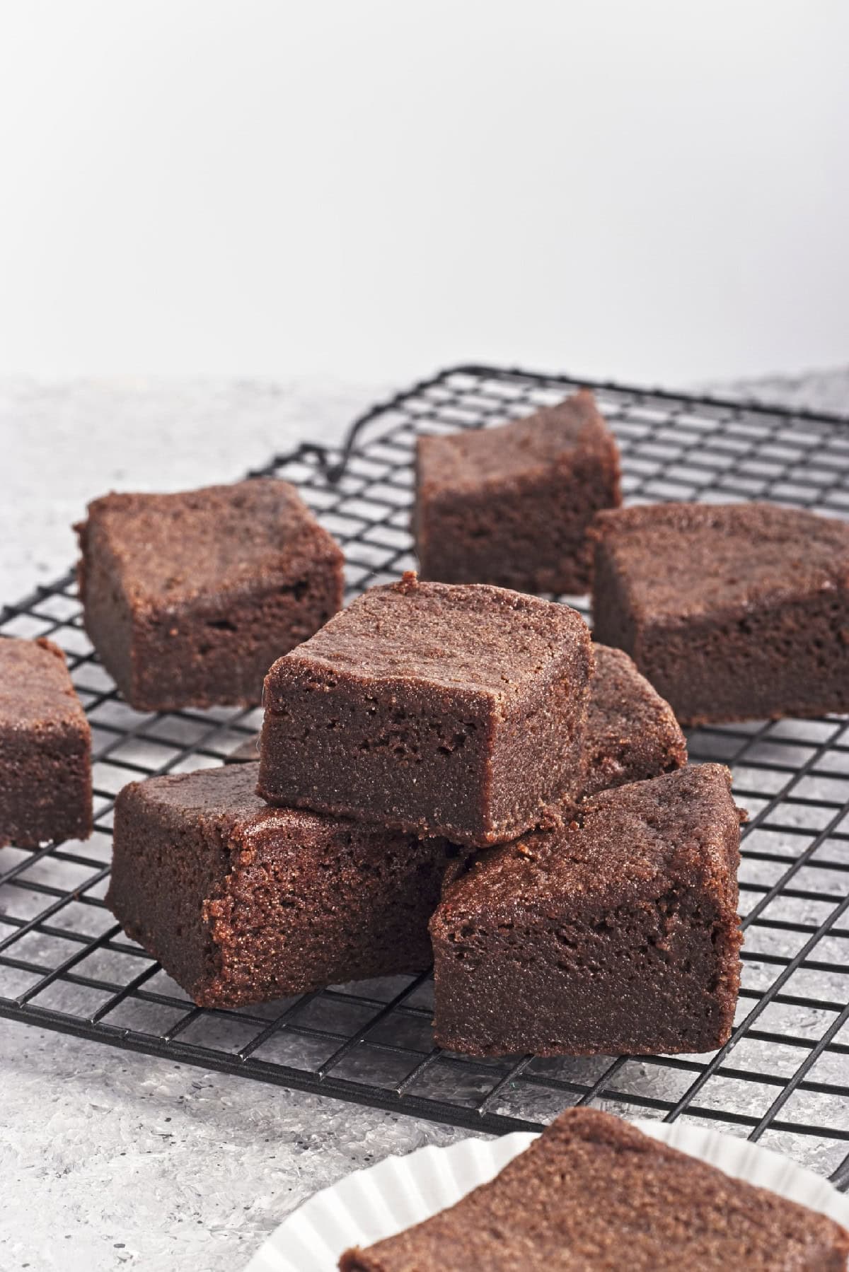 A delicious pile of brownies rests on a cooling rack.