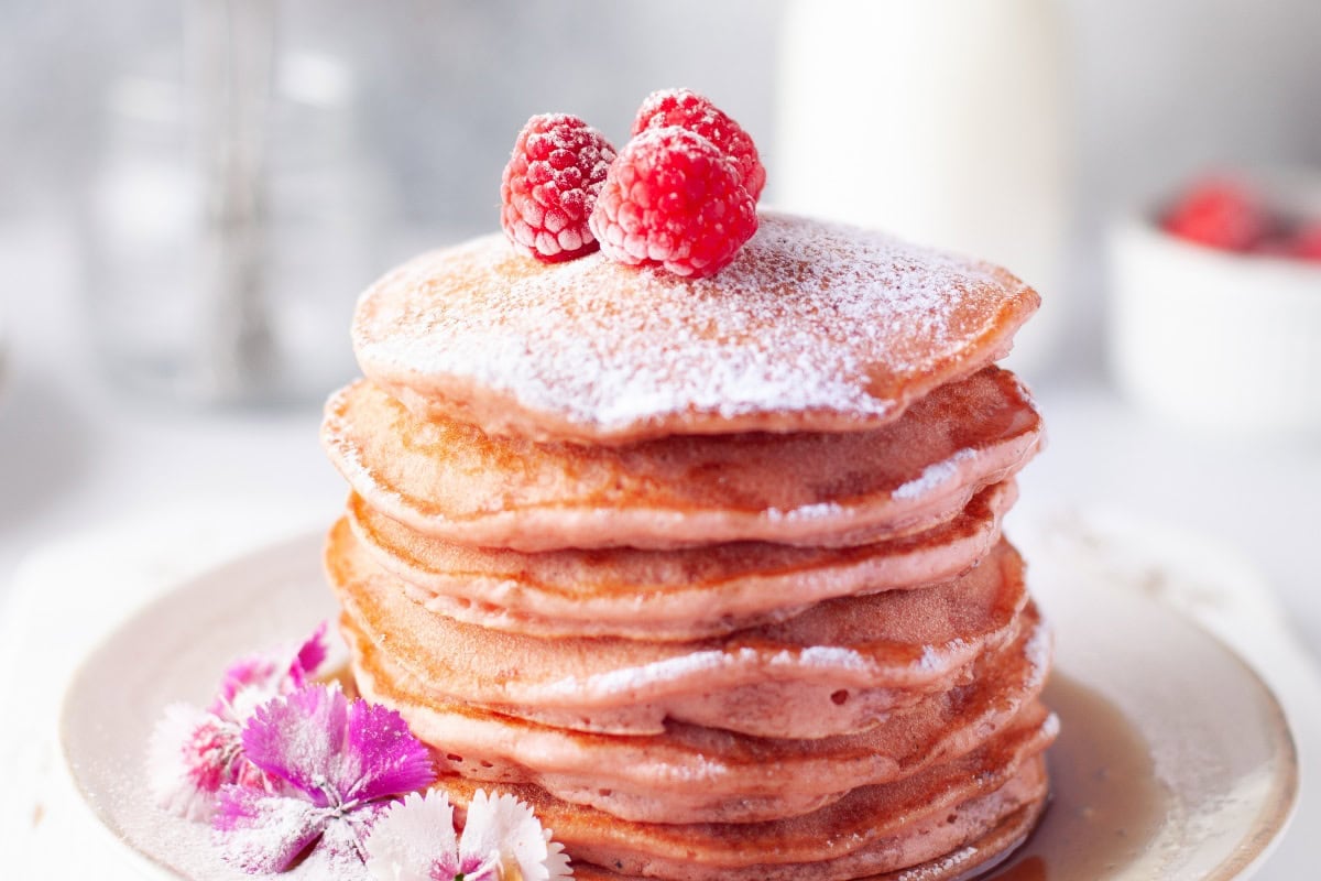 Fluffy beetroot pancakes in a vibrant pink hue.
