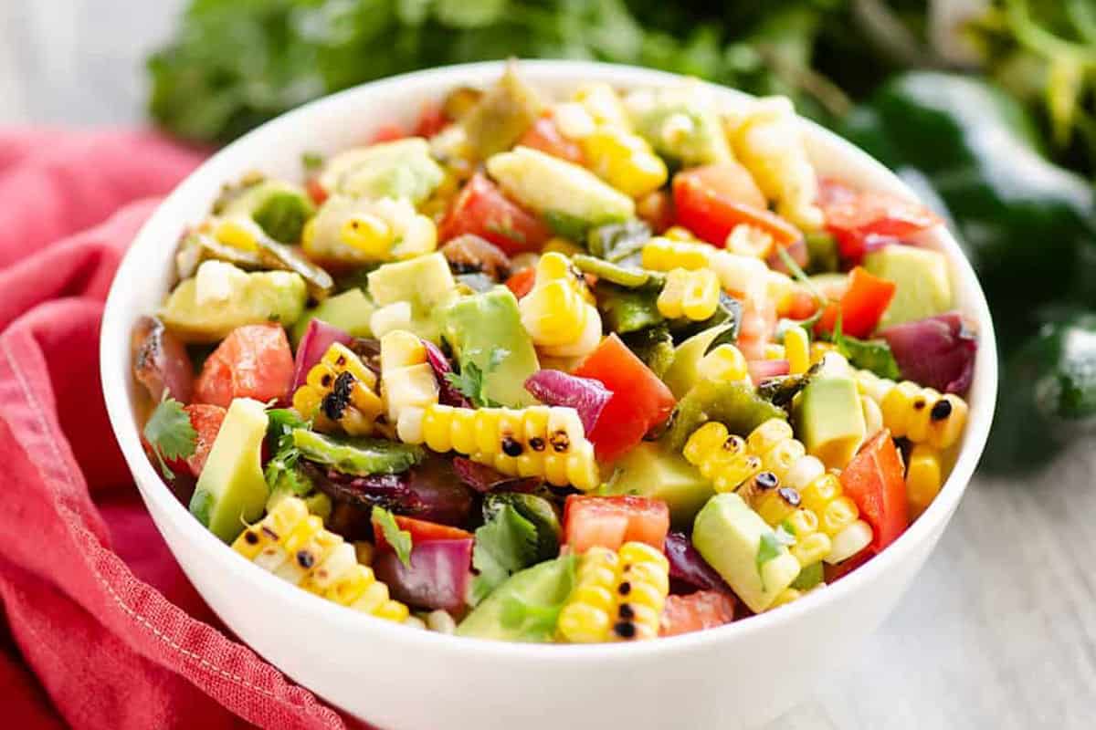 Salad with grilled corn, avocado, and fresh herbs.