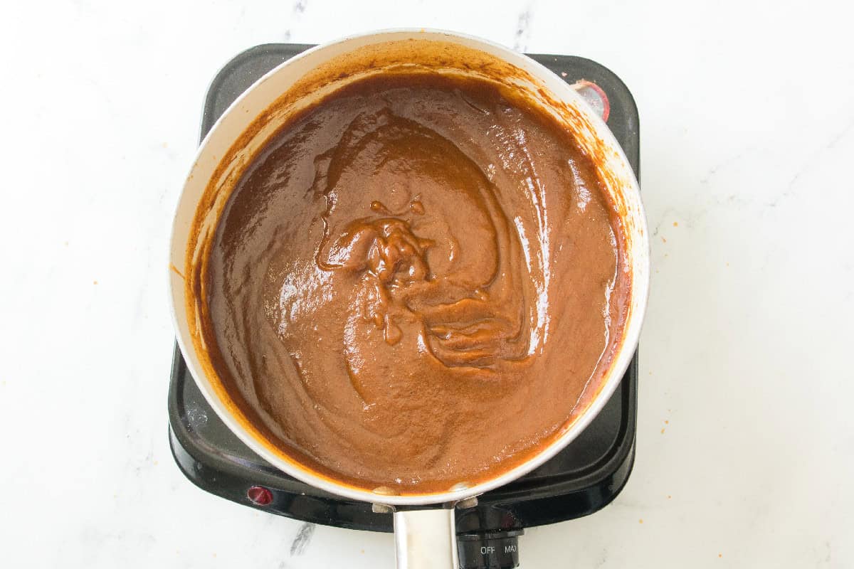 Finished thick pumpkin butter cooling in a saucepan.