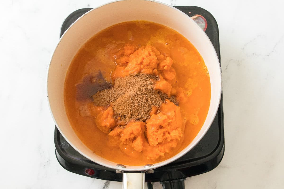 Pumpkin puree with added spices in a saucepan.