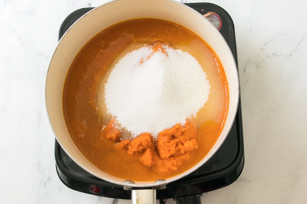 Pumpkin puree with sugar added in a saucepan.