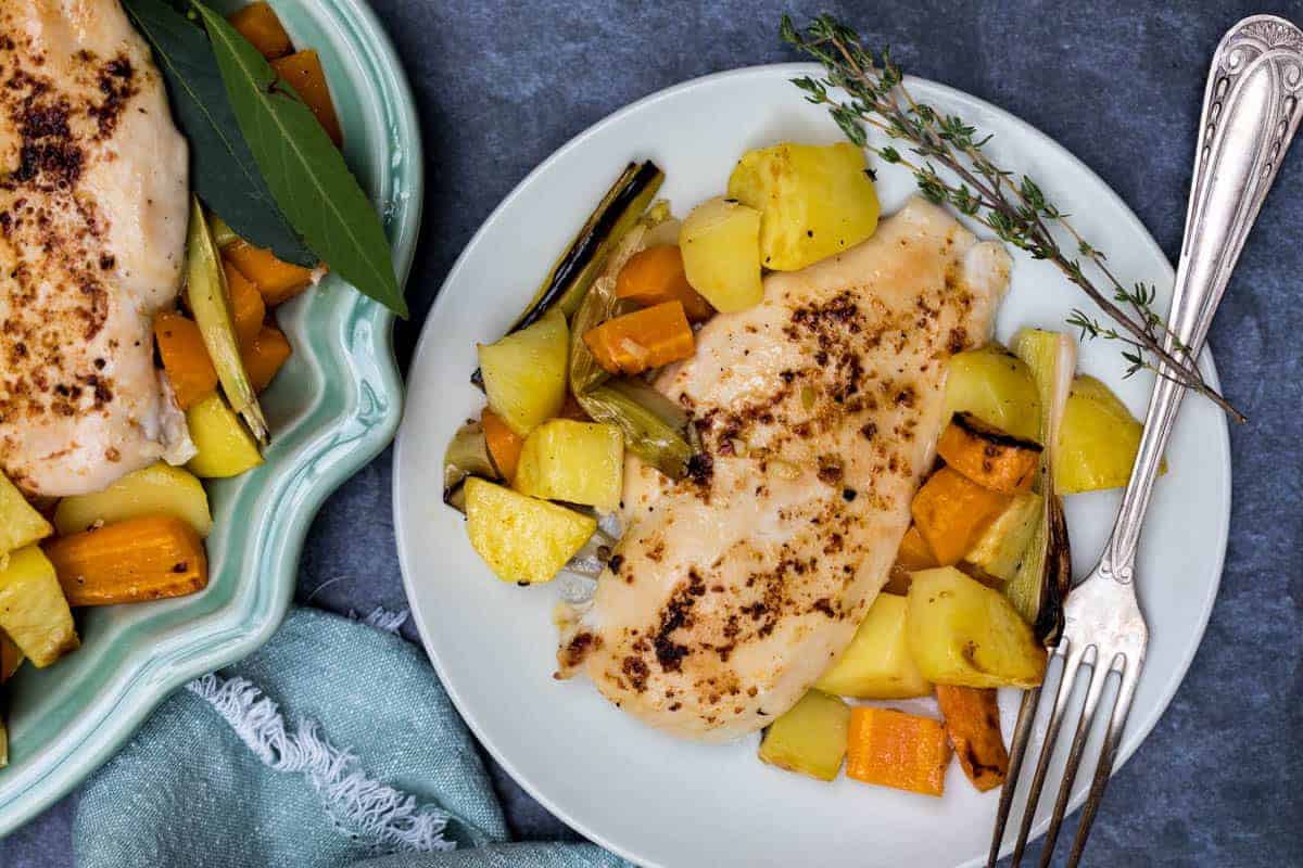 Chicken pieces and potatoes roasted together on one sheet pan.