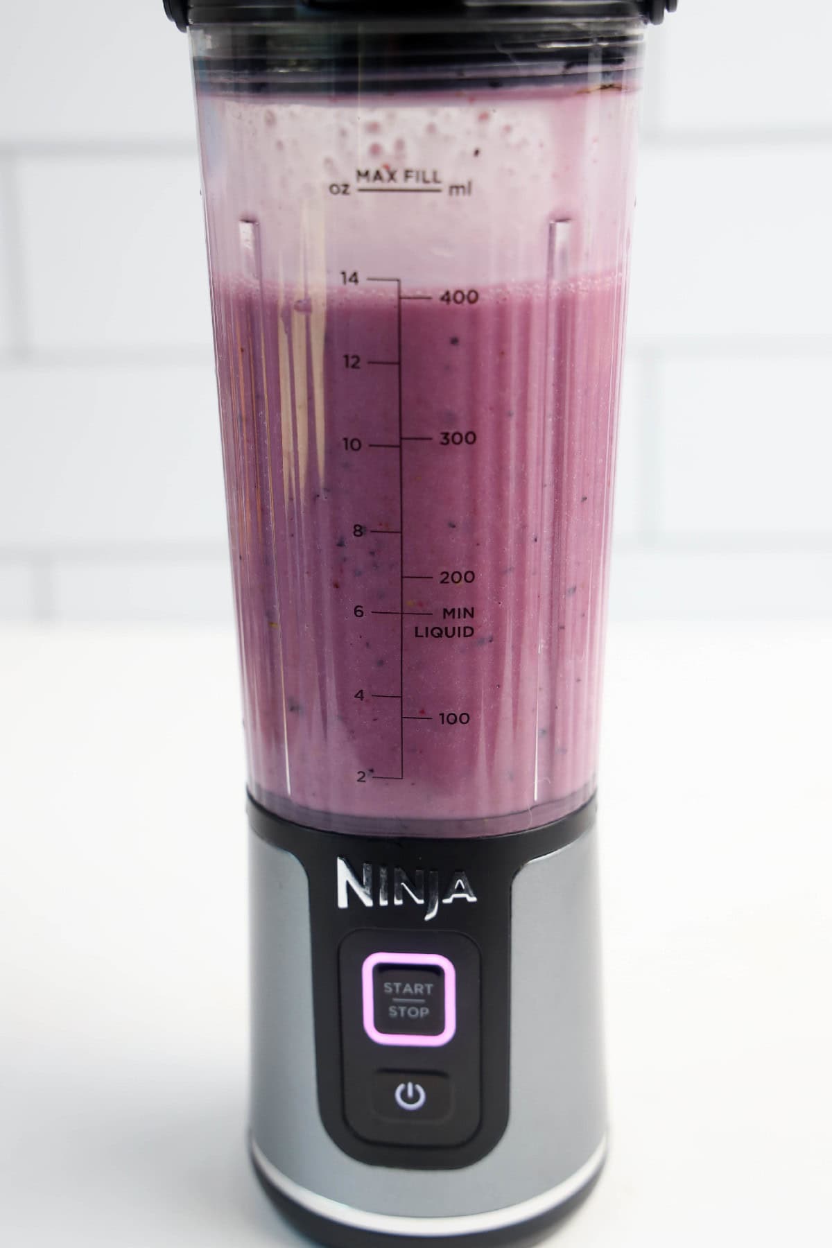 Fully blended vegan triple berry smoothie in a Ninja blender cup.