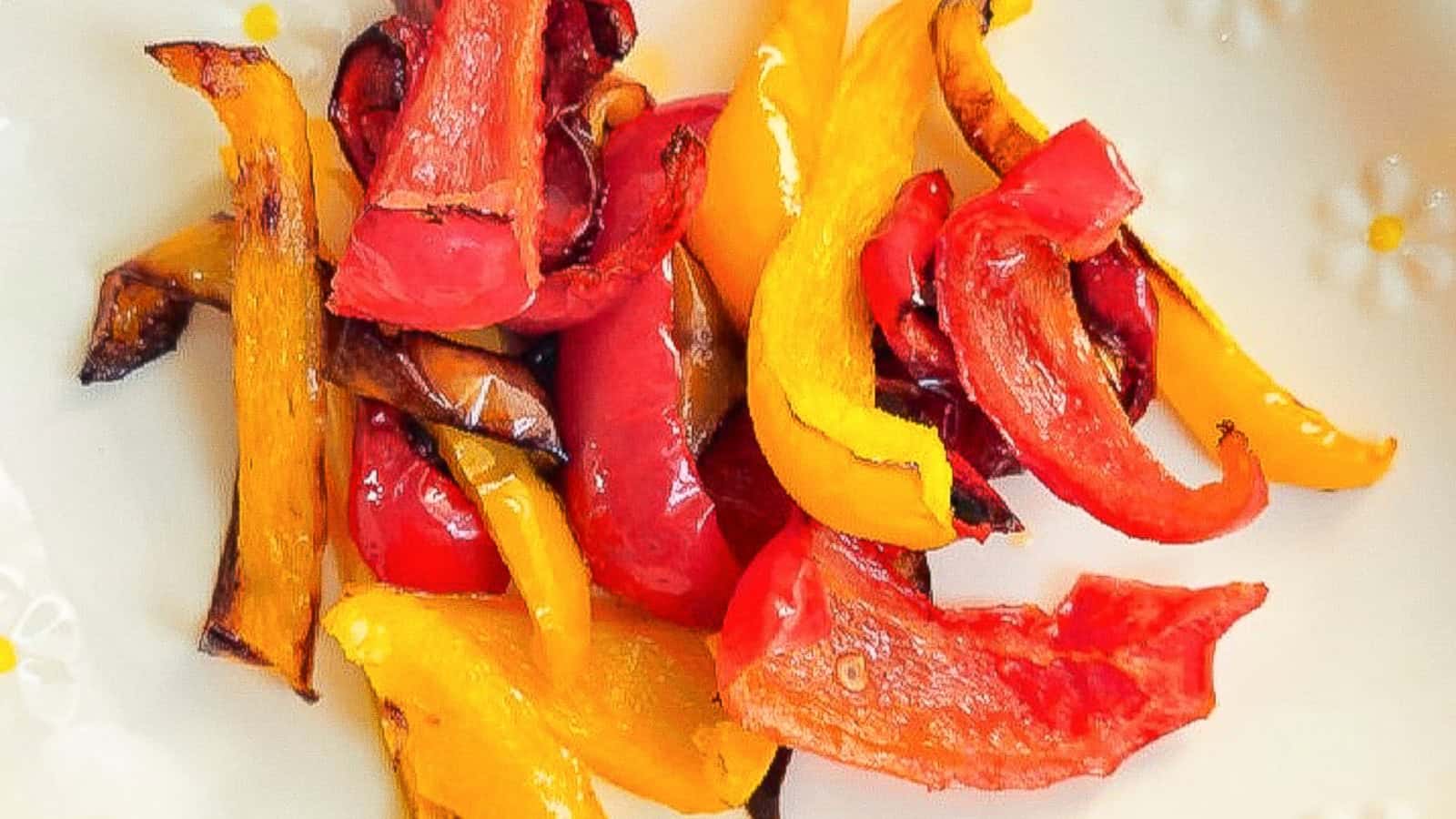 Colorful red and yellow peppers roasted in the air fryer, served on a white dish.