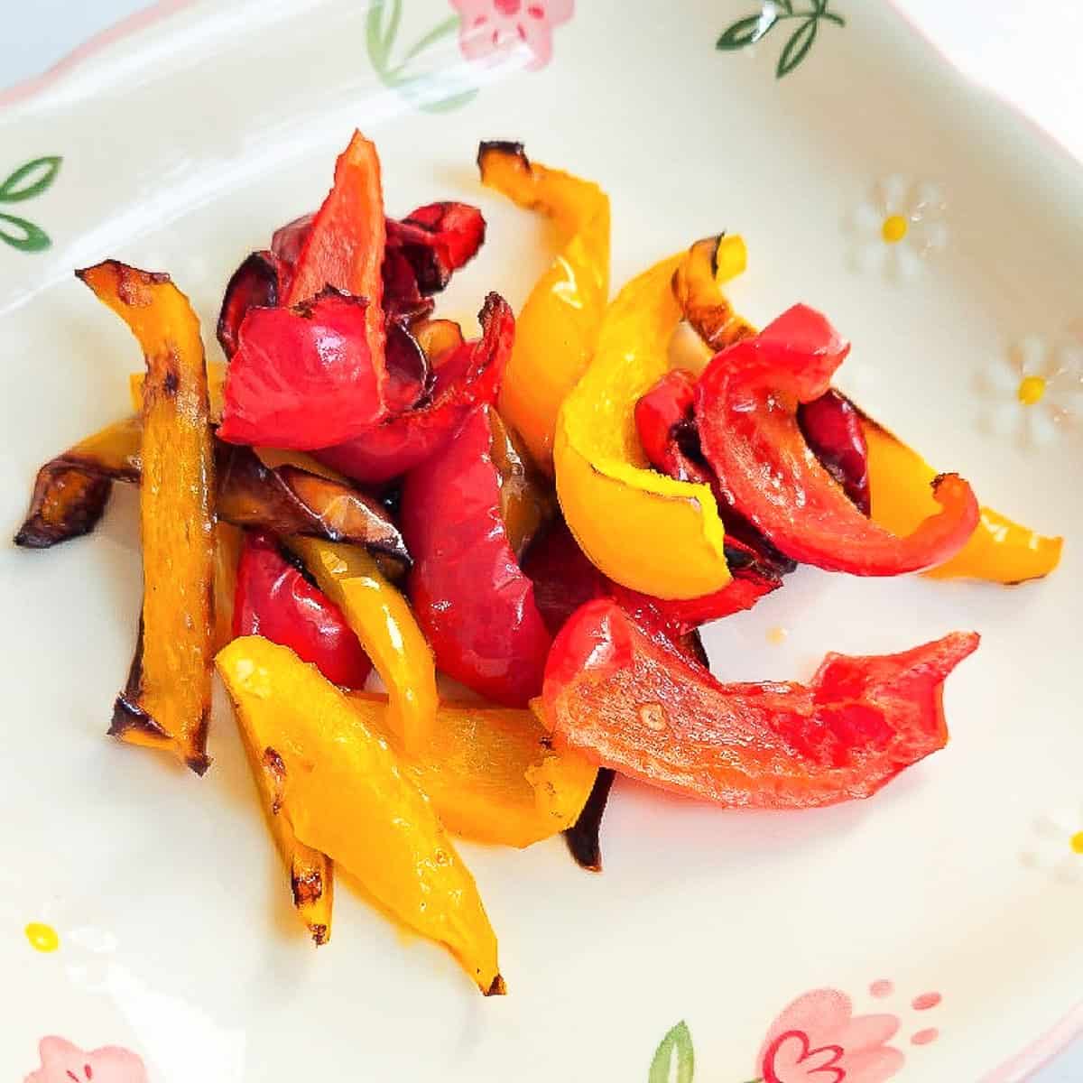 Brightly roasted red and yellow bell peppers with caramelized edges, perfect for a healthy side.