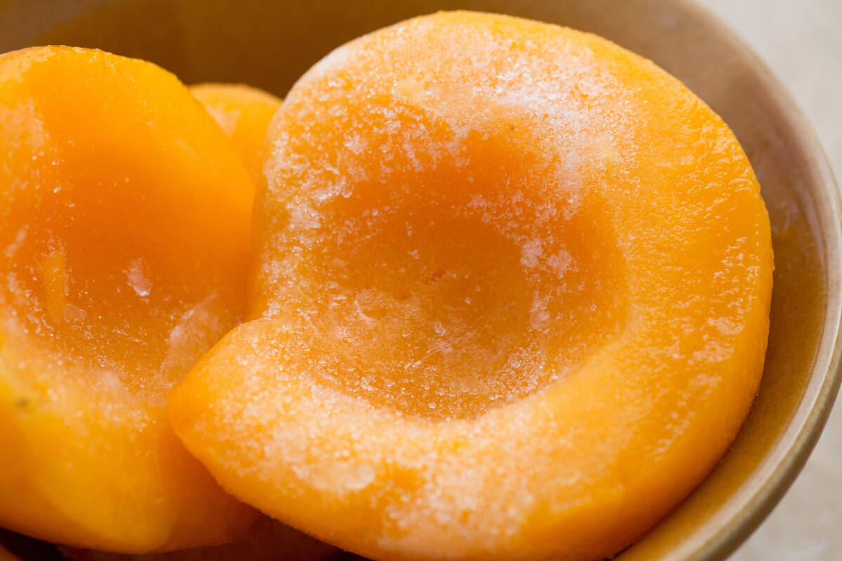 Close-up of frozen peach halves.