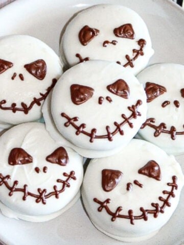 Halloween Jack Skellington cookies served on a round white plate.