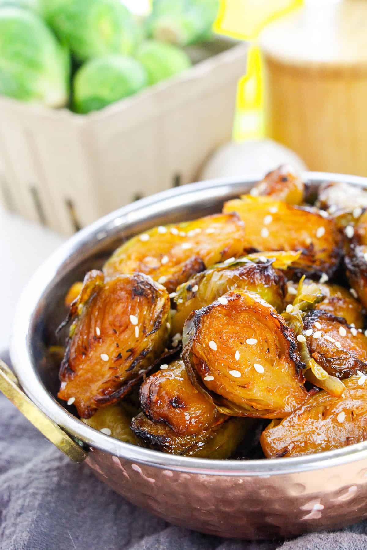 Close-up of roasted Brussels sprouts with a spicy-sweet glaze and sesame seed topping.