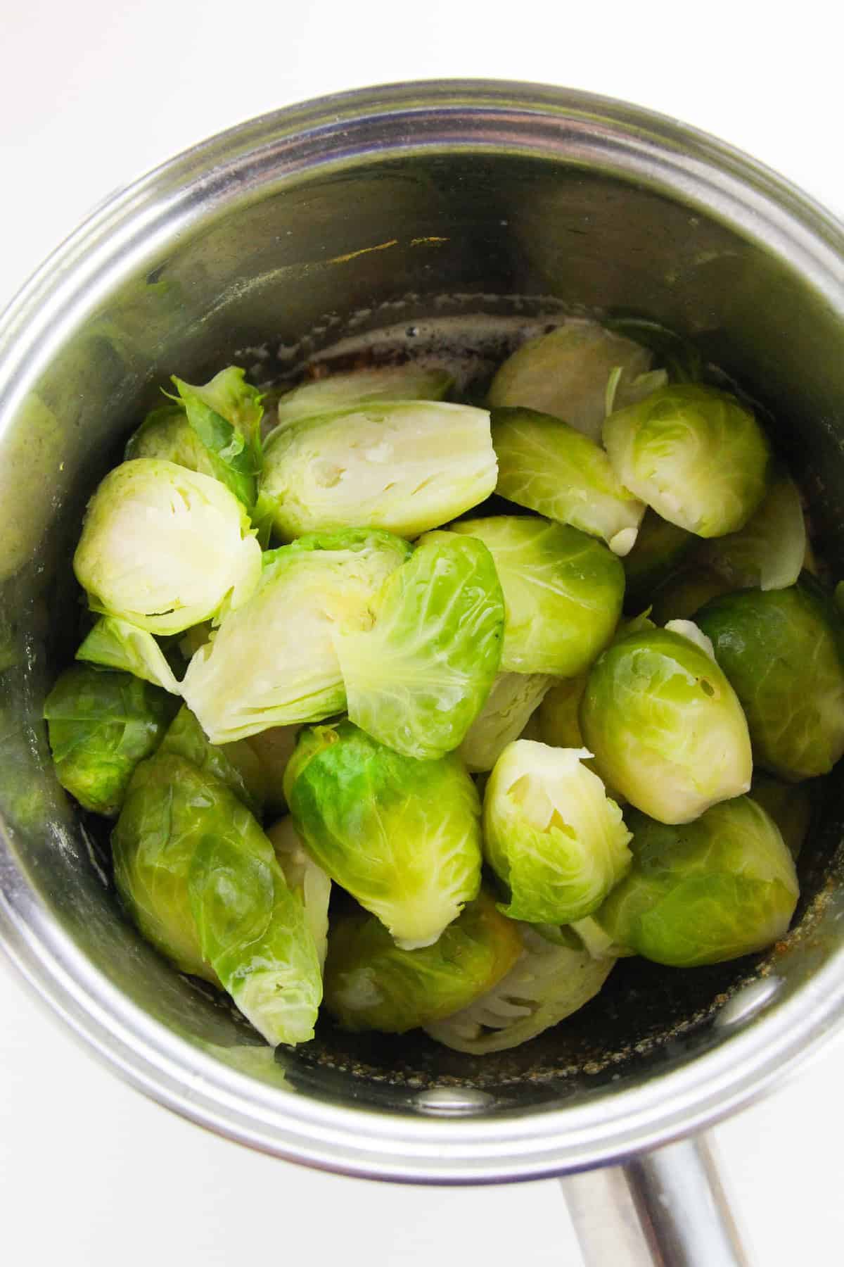Freshly boiled Brussels sprouts in a stainless steel pot.