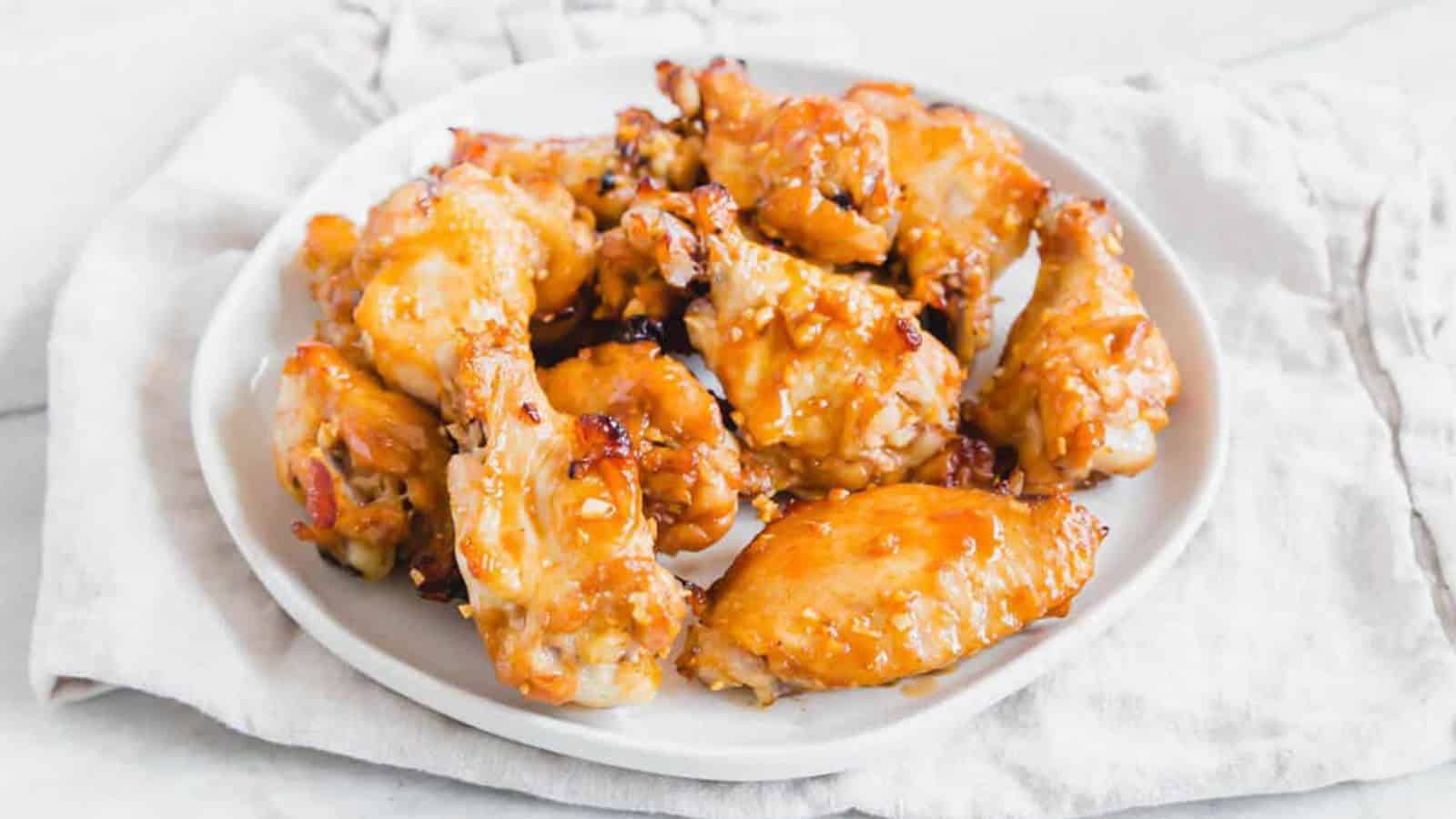 Marinated chicken wings glazed and garnished in skillet.