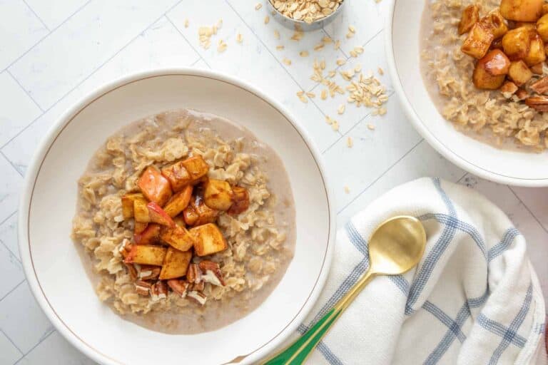 A warm bowl of apple cinnamon oatmeal topped with fresh apple slices and a sprinkle of cinnamon.