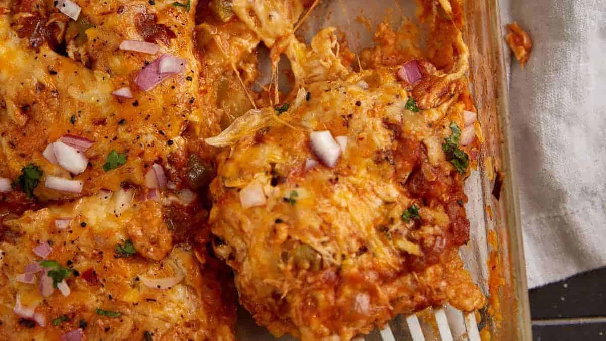 Layered chicken enchilada casserole with cheese.